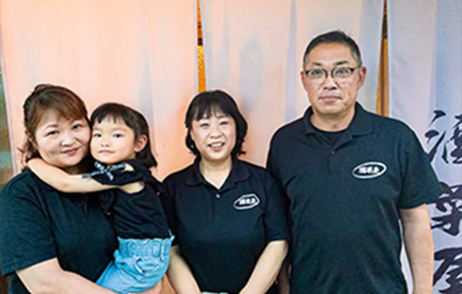 店主と従業員が玄関前で笑顔で立っている