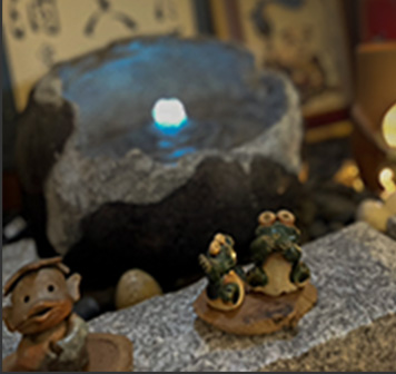 青く光る石明かりの手前にある河童や蛙の置物